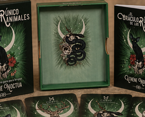 El Oráculo Rúnico de los Animales con libro y cartas, edición Athene Noctua, presentado con cristales y vela.